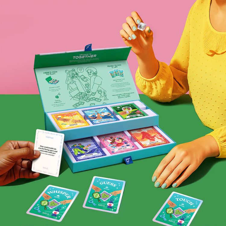 Colorful couples card game set open on table with illustrated cards and game instructions, House of Vices
