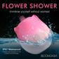Pink rose-shaped waterproof stimulator partially submerged in water, House of Vices wellness store.