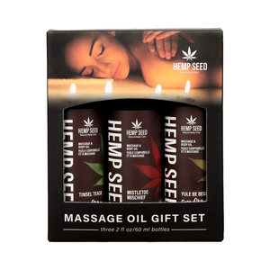 Earthly Body Hemp Seed Holiday Massage Oil Gift Set with Tinsel Tease, Mistletoe Mischief, Yule Be Begging oils in holiday packaging.