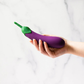 Hand holding a purple eggplant-shaped wellness toy against a marble background, House of Vices