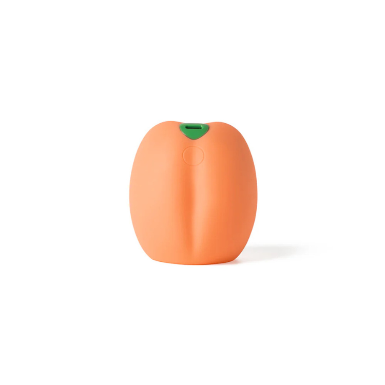 Orange peach-shaped vibrating wellness toy with green top on a white background