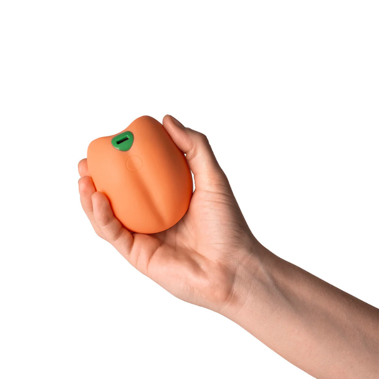 Hand holding a peach-shaped silicone wellness massager, House of Vices adult store