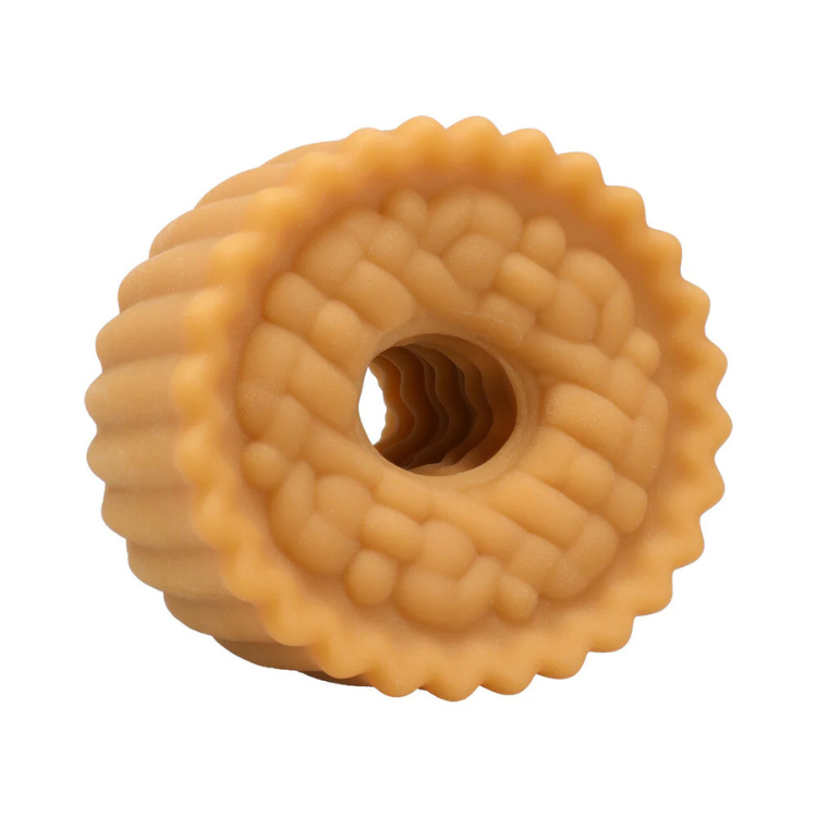 Close-up of a textured, round beige rubber or silicone ring with a hollow center on a white background
