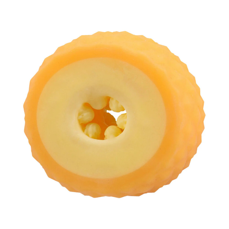 Close-up of a textured yellow pineapple-shaped silicone object with an open center and inner nubs