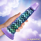 Hand holding iridescent dragon scale textured adult toy with purple base against cloudy sky