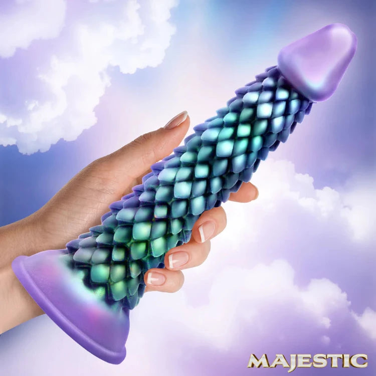 Hand holding iridescent dragon scale textured adult toy with purple base against cloudy sky
