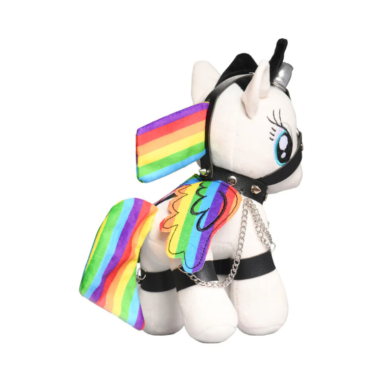Plush white unicorn toy with rainbow wings and tail, wearing black harness and chains