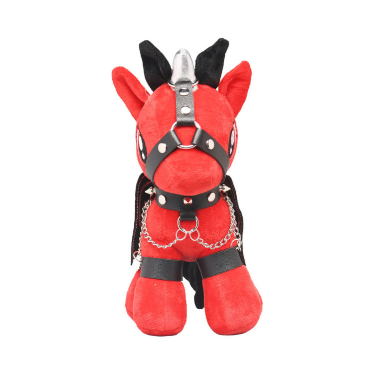 Red plush pony in black faux leather harness with chains and silver horn, on white background