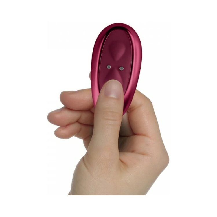 Hand holding an ergonomic pink saddle vibrator for adult wellness