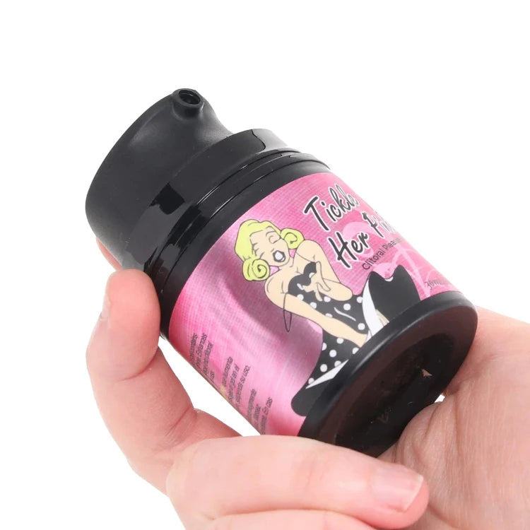 A person holding a Tickle Her clitoral pleasure lubricant bottle.