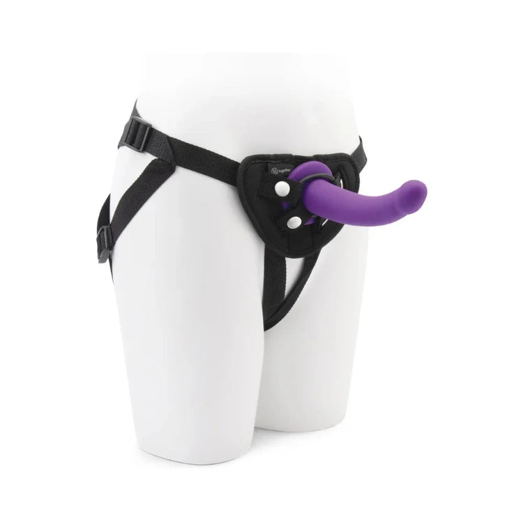 Purple strap-on dildo attached to a black harness on a white mannequin torso.