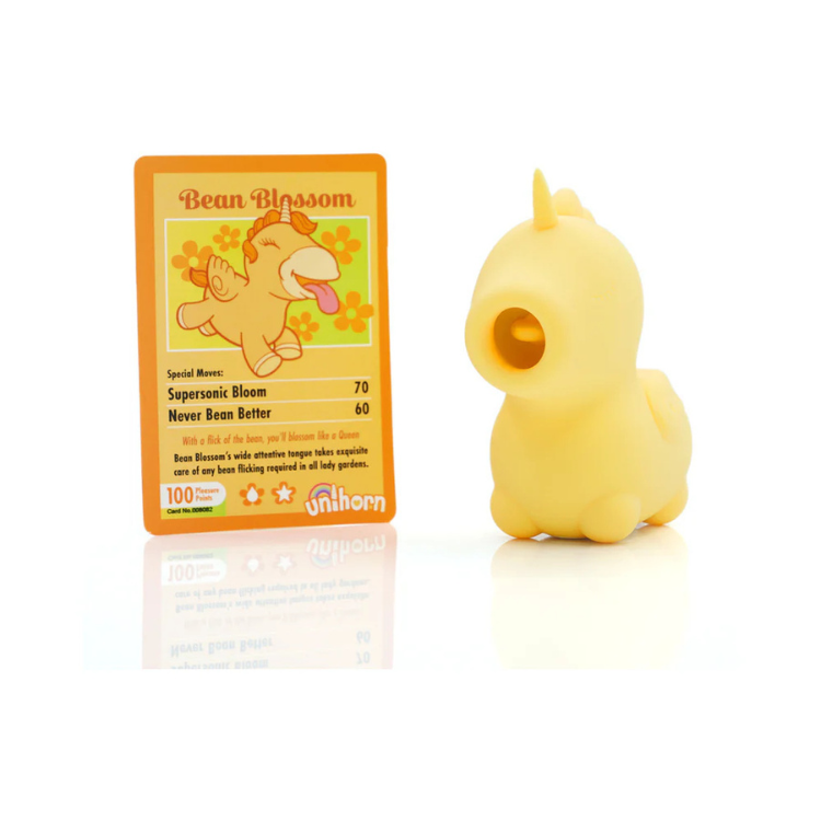 Yellow unicorn-shaped flicking vibrator next to Bean Blossom info card on white background.