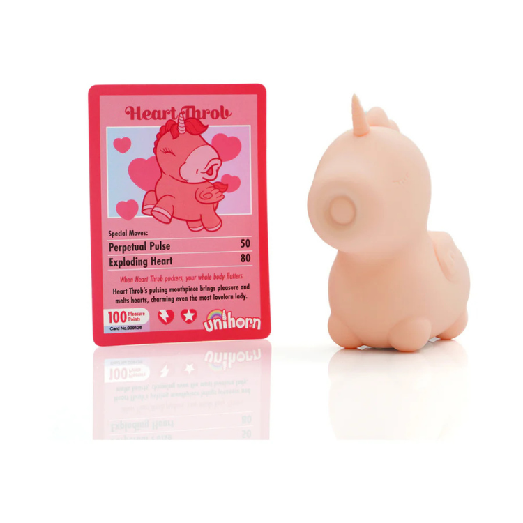 Pink unicorn-shaped pulsing vibrator beside illustrated info card, novelty adult toy